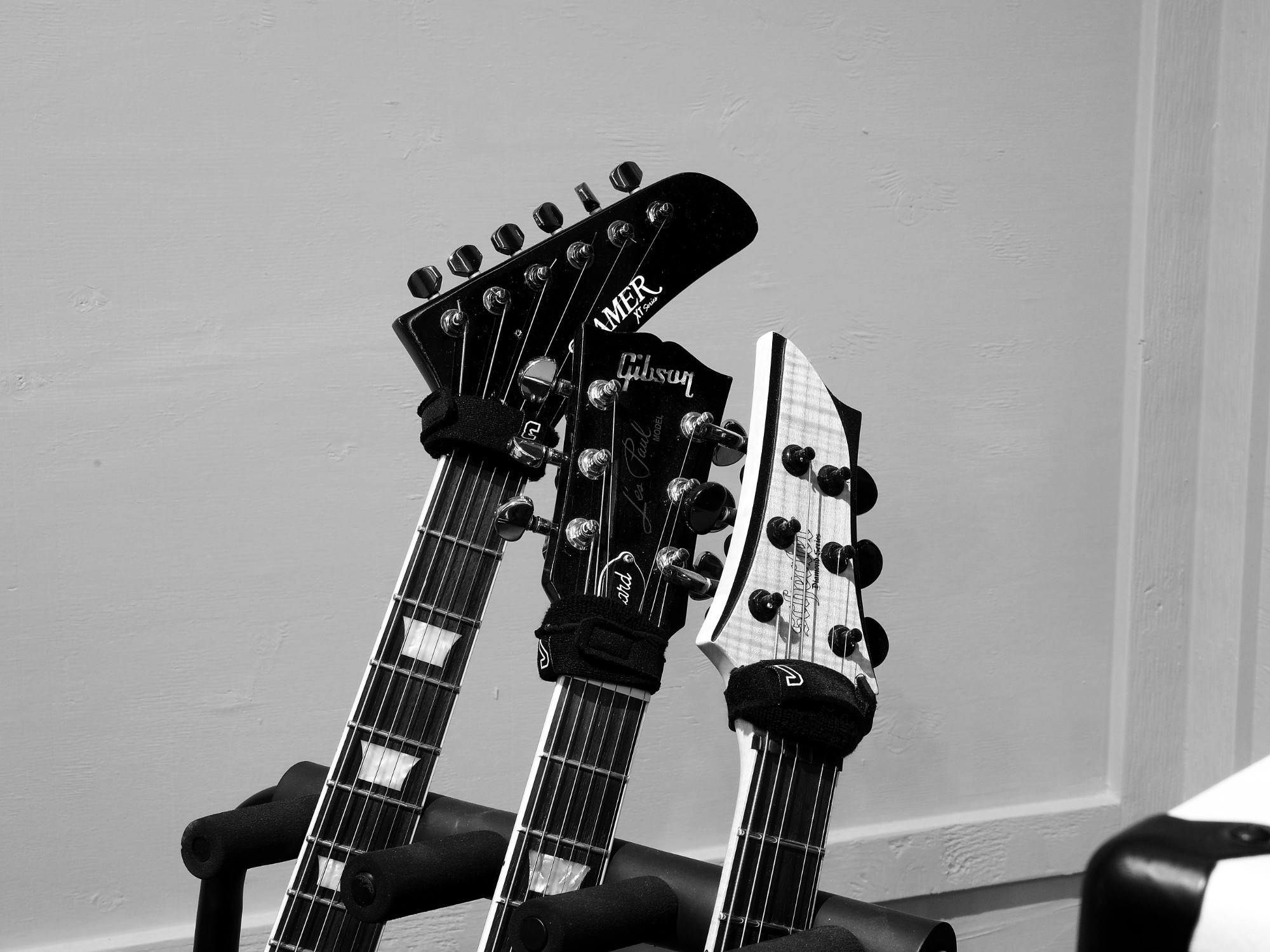 Three electric guitar headstocks on a stand at Sound Corral Studios